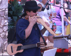 A vendor demonstrates the sounds his instruments can make to passerby at the festival.