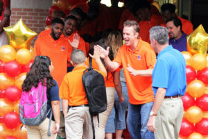 Angelina College head men's basketball coach Kyle Manary (right) greets incoming Kurth Elementary students during Monday's first day of school. Manary and the rest of the Roadrunner team formed a welcome line complete with high fives and fist bumps for each youngster and faculty member who came through the doors. (AC Press photo/Gary Stallard)