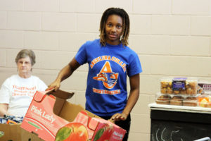 Angelina College’s Tyanna Barlow helps organize food distributions Friday at the Christian Information Center in Lufkin. The Lady Roadrunner basketball team helped assemble and distribute food for the CIC, the area’s largest food pantry responsible for feeding approximately 14,000 people per month. (AC Press photo by Gary Stallard)