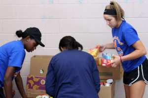 Angelina College Lady Roadrunner basketball players LaNeique Nealey (left) and Karley McHenry assist a customer during Friday’s volunteer efforts at the Christian Information Center in Lufkin. The Lady Roadrunner basketball team helped assemble and distribute food for the CIC, the area’s largest food pantry responsible for feeding approximately 14,000 people per month. (AC Press photo by Gary Stallard)