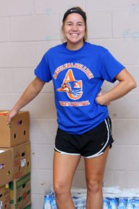 Karley McHenry of Angelina College awaits the next customer after stacking food items during Friday’s volunteer efforts at the Christian Information Center in Lufkin. The Lady Roadrunner basketball team helped assemble and distribute food for the CIC, the area’s largest food pantry responsible for feeding approximately 14,000 people per month. (AC Press photo by Gary Stallard)